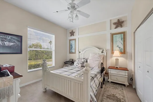 a bedroom with a bed a chandelier and dresser