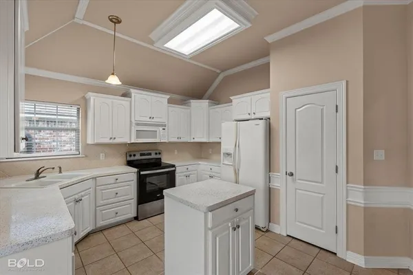 a kitchen with white cabinets and appliances