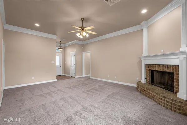 an empty room with fireplace fan and windows