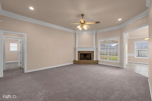 a view of an empty room with a fireplace and a window