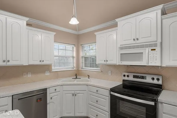 a view of an empty room with a window and a chandelier fan