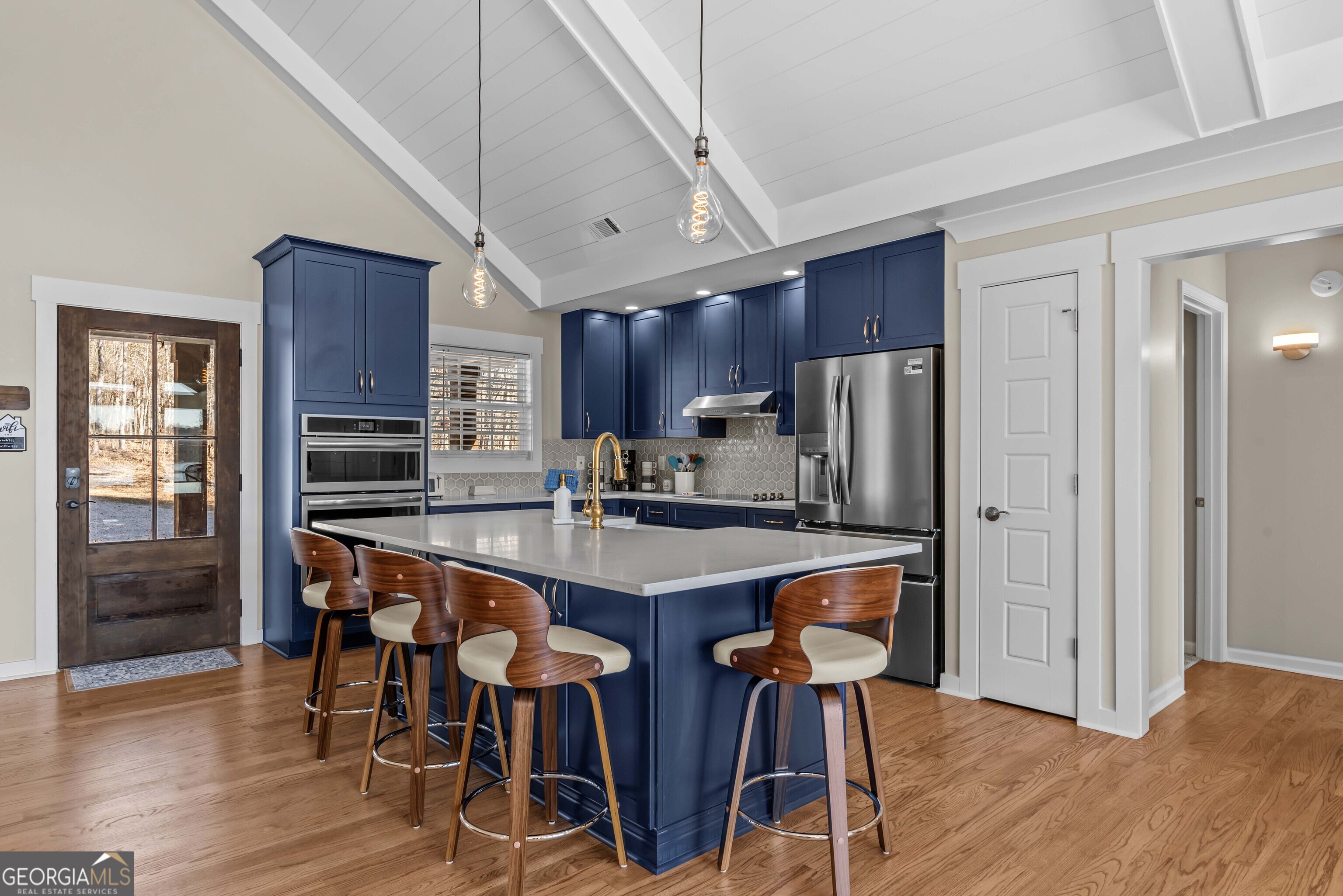 766 South Steel Bridge Road Eatonton, GA 31024 - Photo 23 of 71 a kitchen with stainless steel appliances granite countertop a table chairs refrigerator and wooden cabinets
