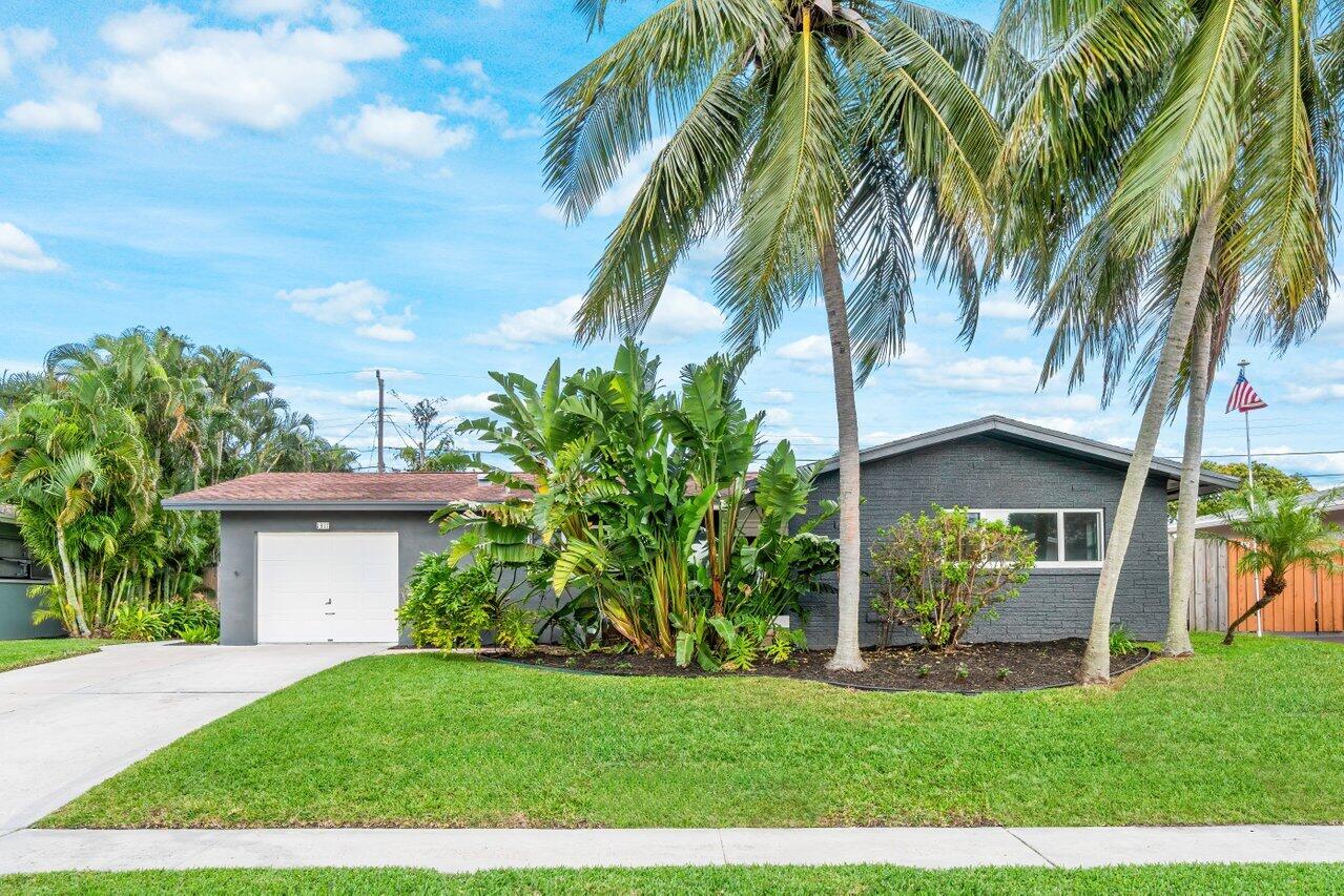 1317 Southwest 9th Street Boca Raton, FL 33486 - Photo 3 of 41 a front view of a house with a garden