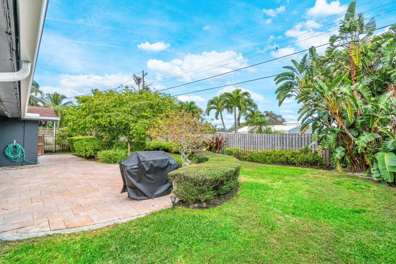 1317 Southwest 9th Street Boca Raton, FL 33486 - Photo 31 of 41 a backyard of a house with table and chairs plants and large tree