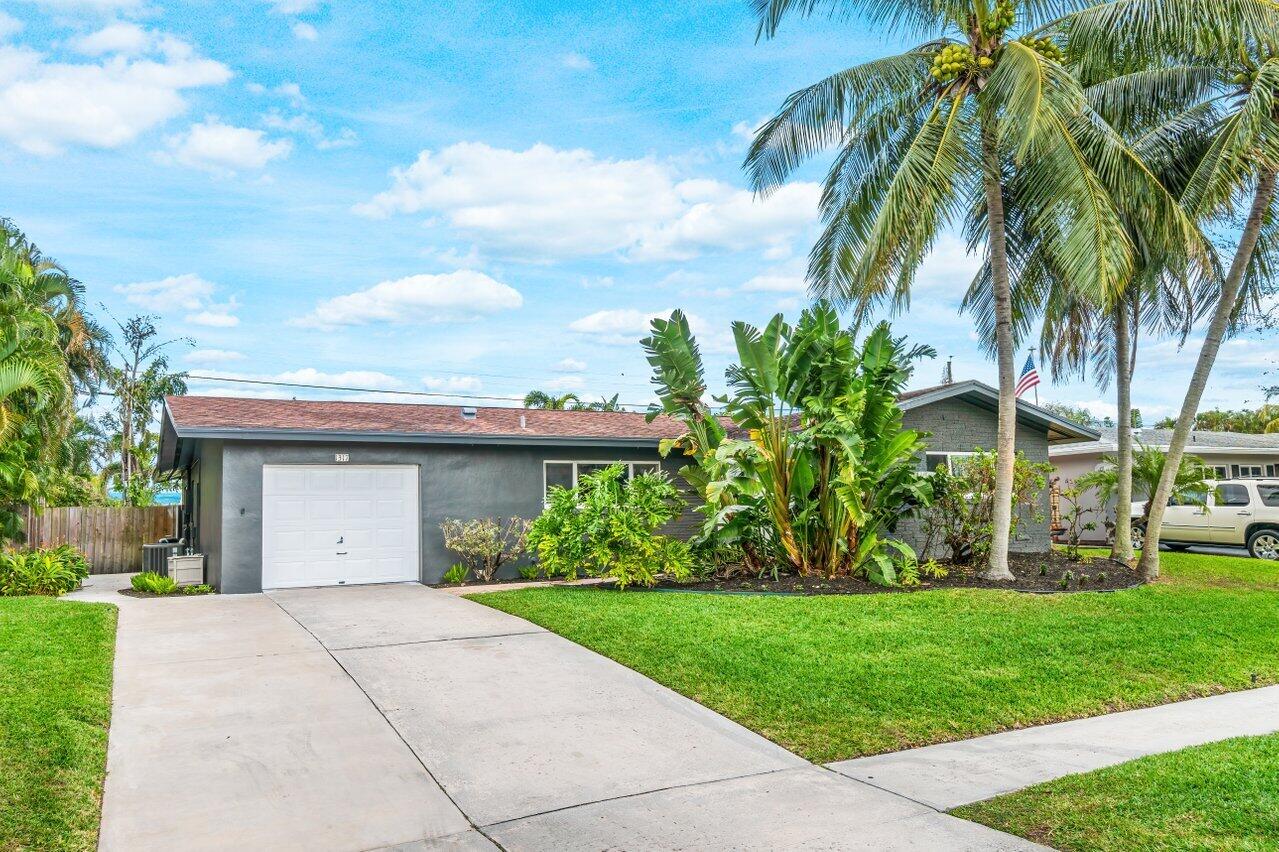 1317 Southwest 9th Street Boca Raton, FL 33486 - Photo 5 of 41 a view of a house with a yard plants and palm trees