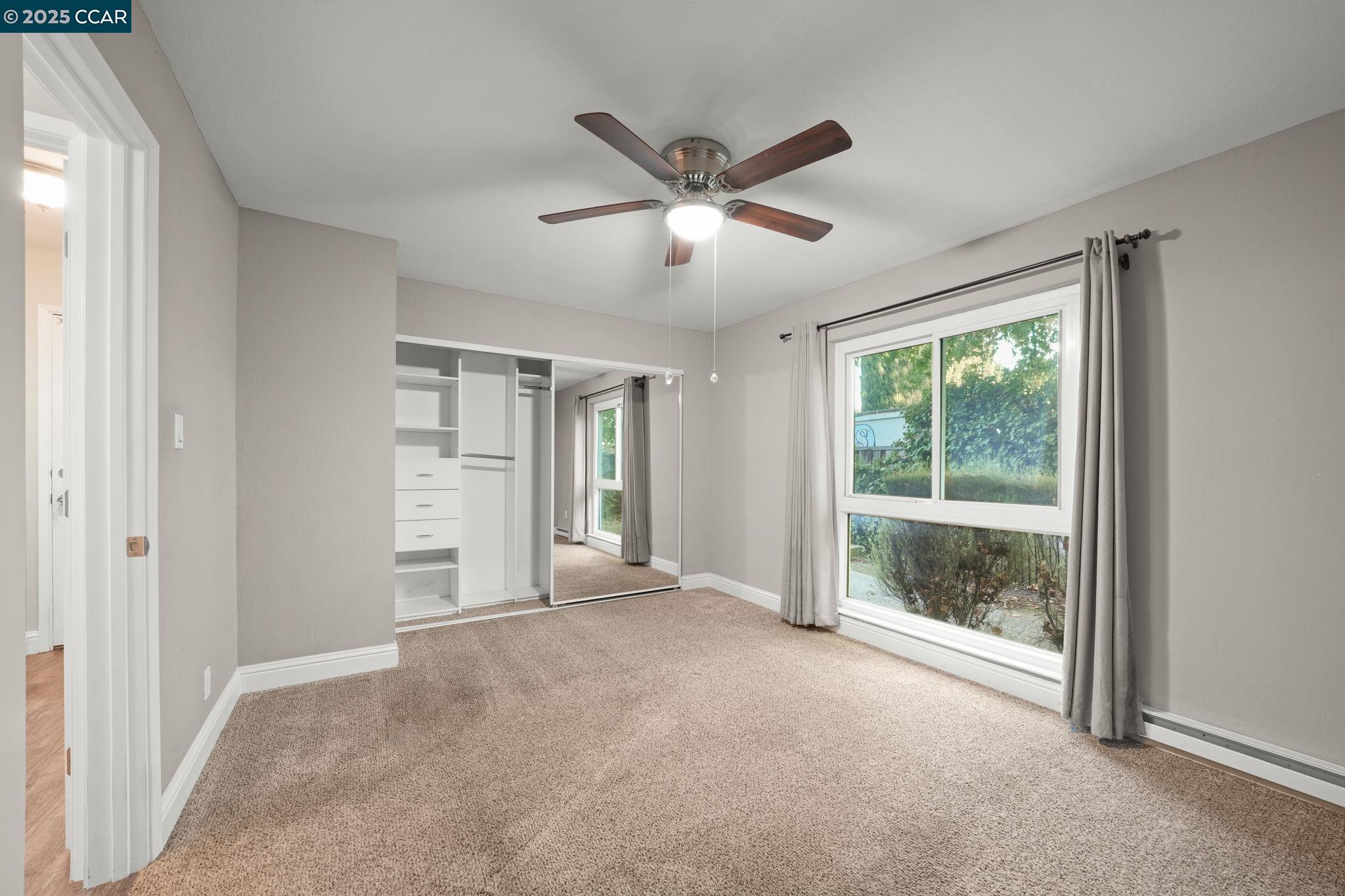 1036 Oak Grove Road, Unit 21 Concord, CA 94518 - Photo 16 of 23 a view of a livingroom with a ceiling fan and windows