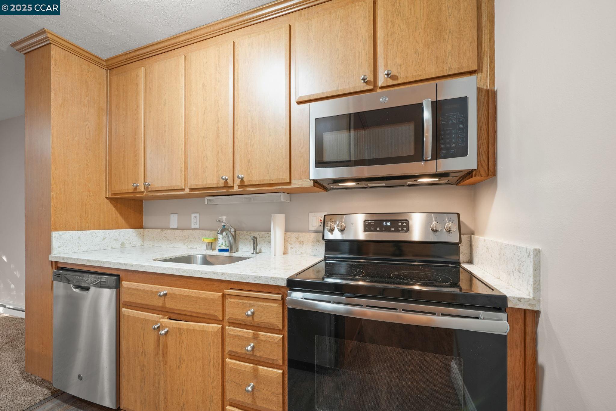 1036 Oak Grove Road, Unit 21 Concord, CA 94518 - Photo 2 of 23 a kitchen with stainless steel appliances granite countertop a stove microwave and cabinets