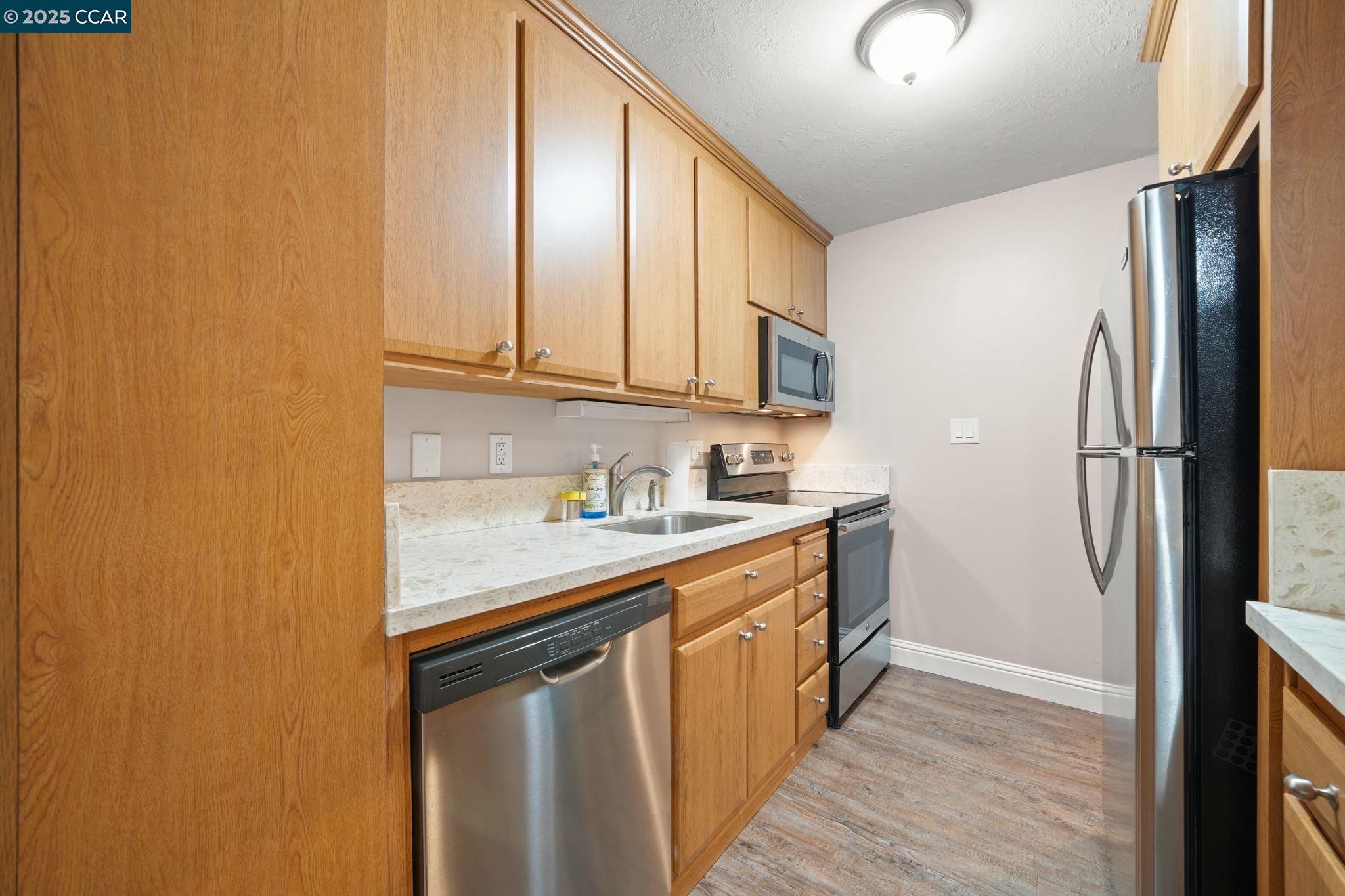 1036 Oak Grove Road, Unit 21 Concord, CA 94518 - Photo 4 of 23 a kitchen with stainless steel appliances granite countertop a stove a sink and a refrigerator