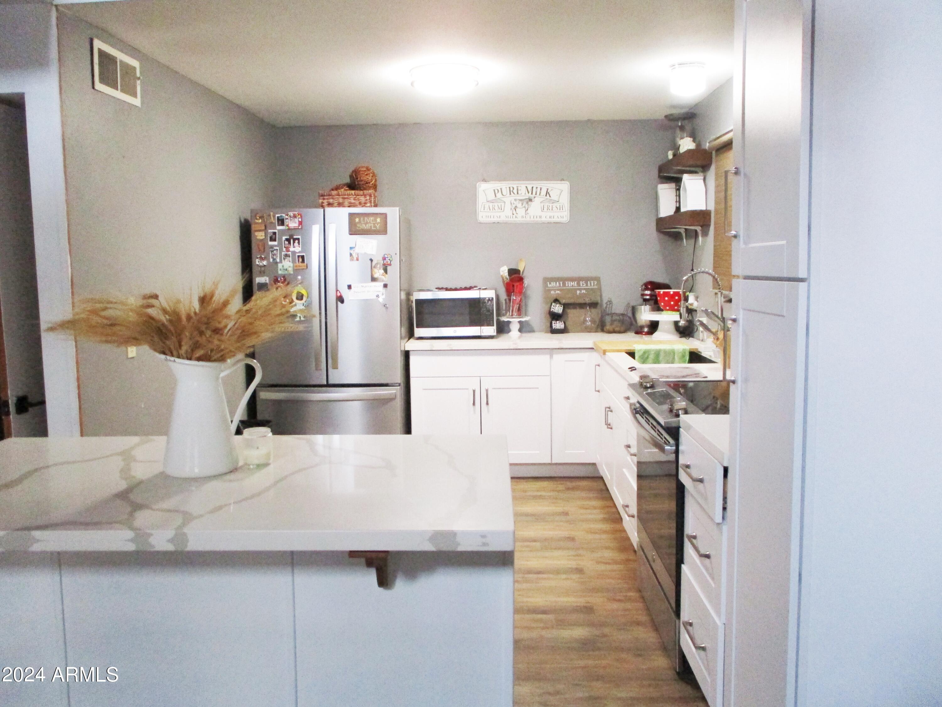 8539 Buffalo Road Strawberry, AZ 85544 - Photo 5 of 19 a kitchen with stainless steel appliances a refrigerator and a stove