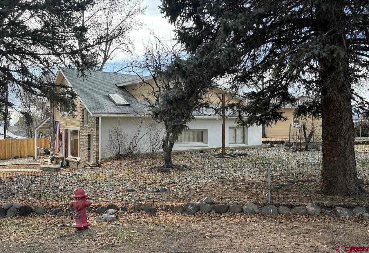 180 Northwest 4th Street Cedaredge, CO 81413 - Photo 2 of 17 a tree in front of a white house