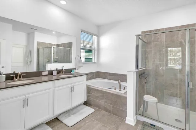 a bathroom with a double vanity sink toilet and shower