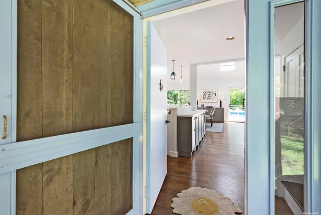 a hallway with wooden floor windows and plants