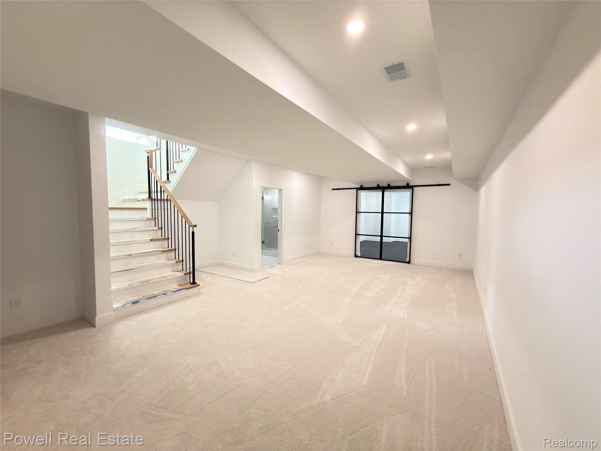 1998 Hazel Street Birmingham, MI 48009 - Photo 20 of 22 Spacious room featuring new carpet, recessed lighting, and a modern barn door with glass panels