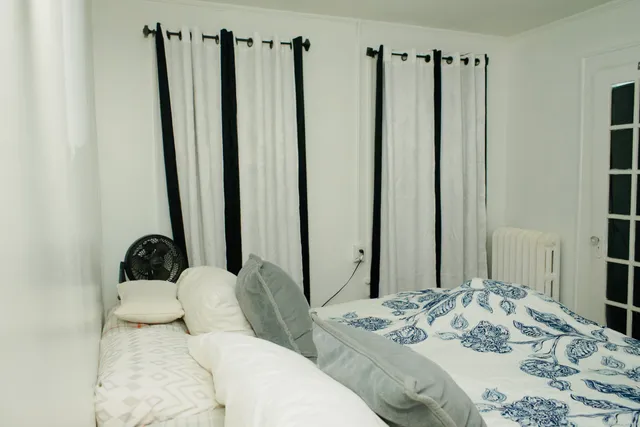 a bedroom with bed and a large mirror