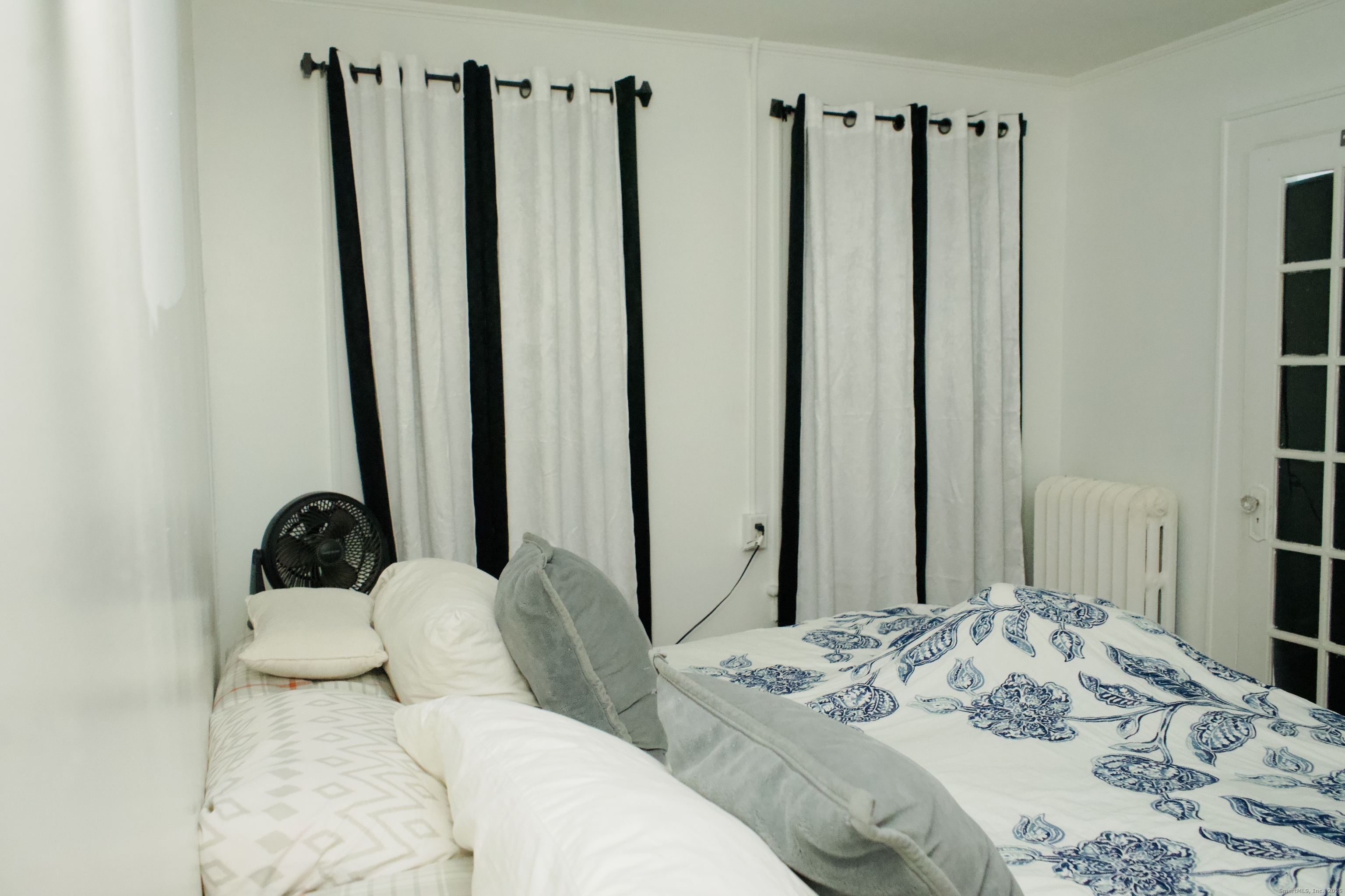 533 Clinton Avenue Bridgeport, CT 06605 - Photo 8 of 18 a bedroom with bed and a large mirror