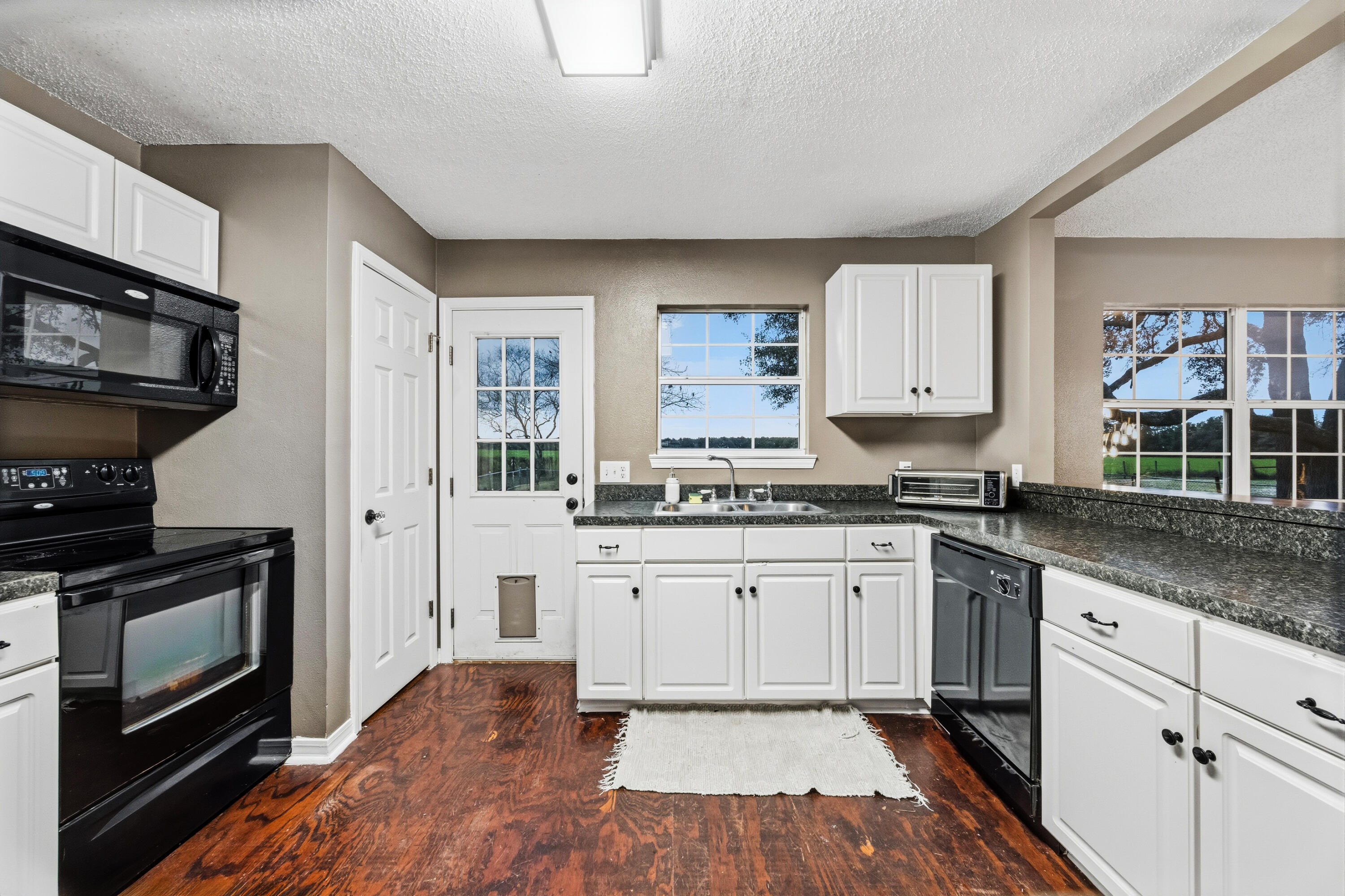 4398 Cooper Lane Holt, FL 32564 - Photo 20 of 53 a kitchen with stainless steel appliances granite countertop a stove a sink and a microwave