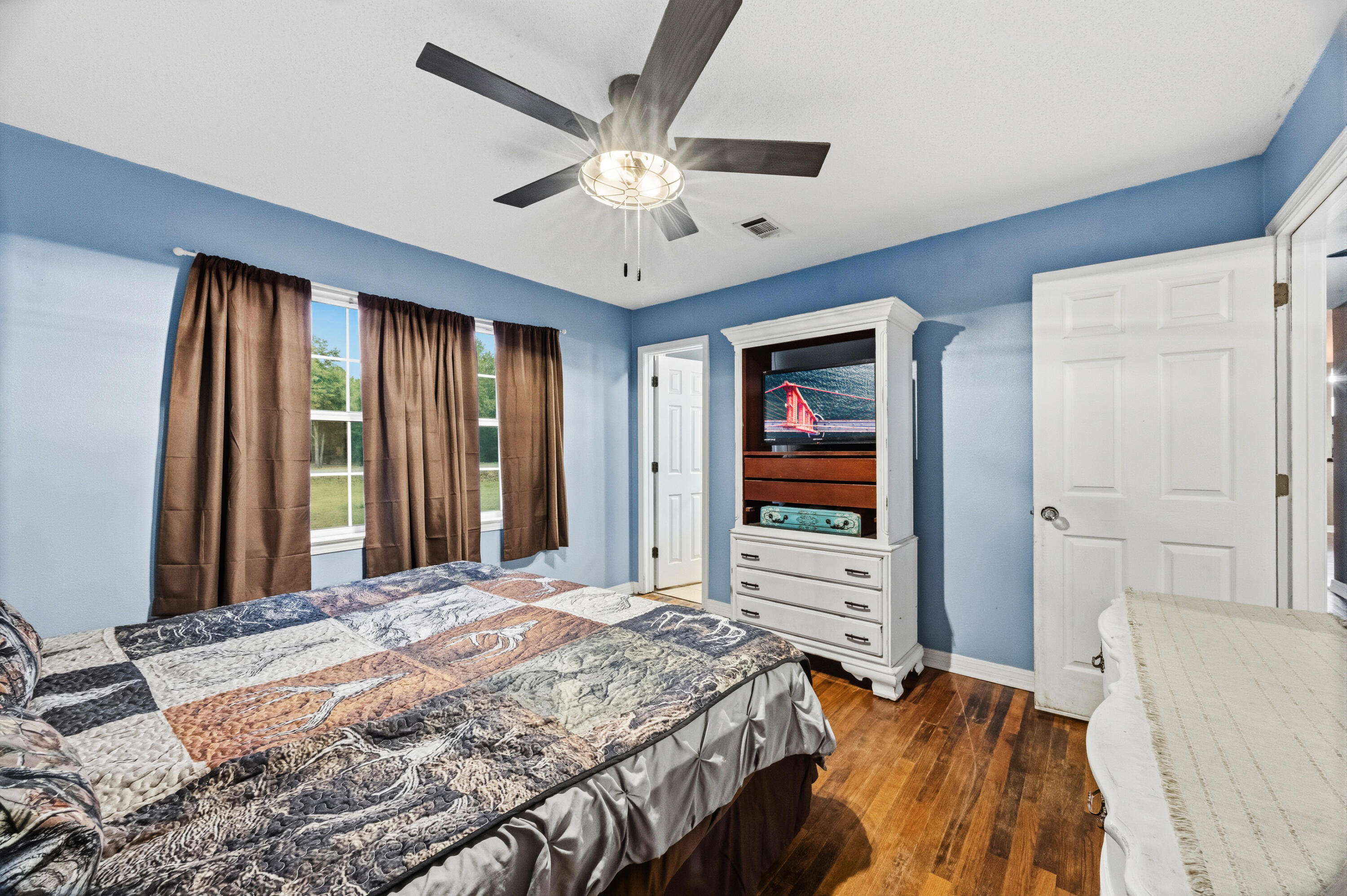 4398 Cooper Lane Holt, FL 32564 - Photo 26 of 53 a bedroom with a large bed and a chandelier