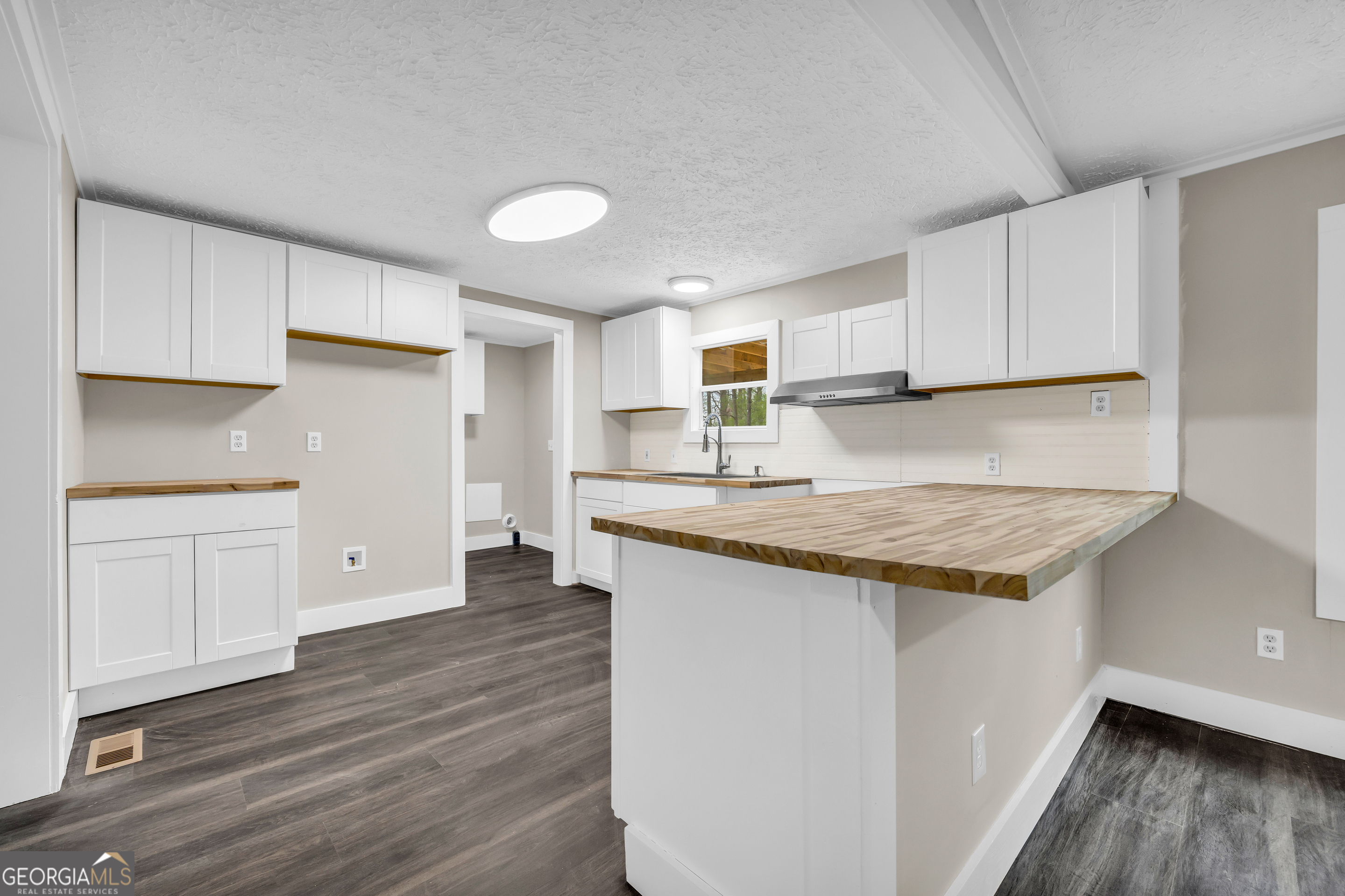 5620 Mize Road Toccoa, GA 30577 - Photo 18 of 37 a kitchen with granite countertop a sink and cabinets with wooden floor