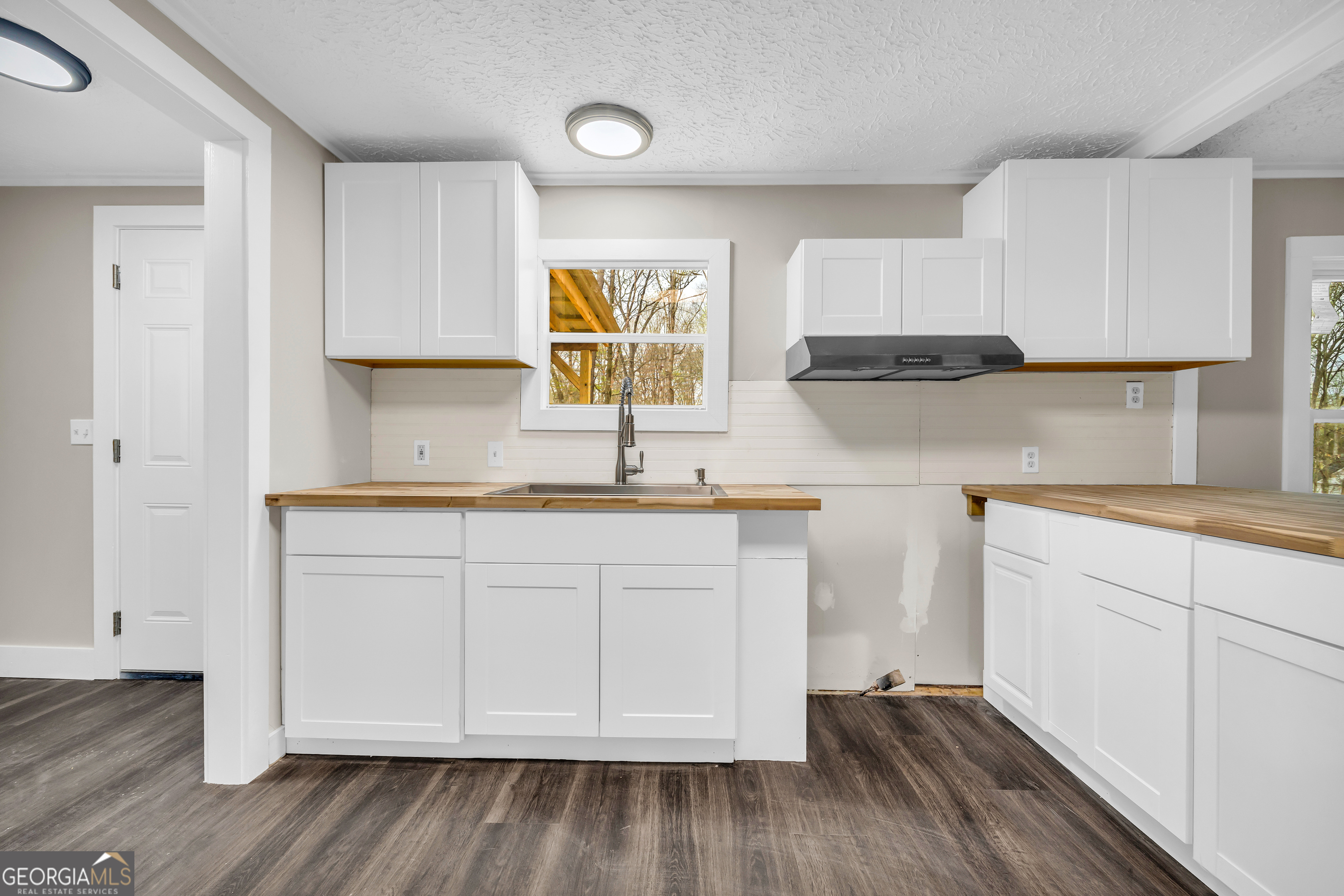 5620 Mize Road Toccoa, GA 30577 - Photo 19 of 37 a kitchen with granite countertop white cabinets and wooden floor