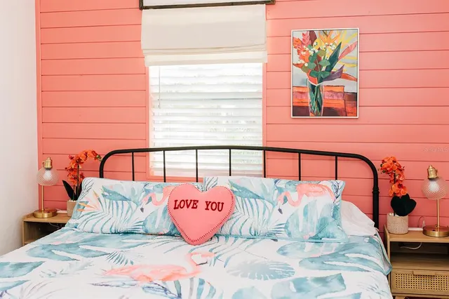 a bed sitting in a bedroom next to a window