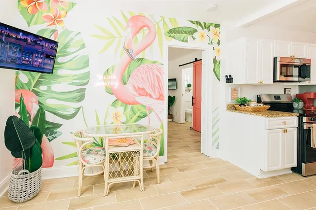 a dining room filled a chandelier and kitchen view
