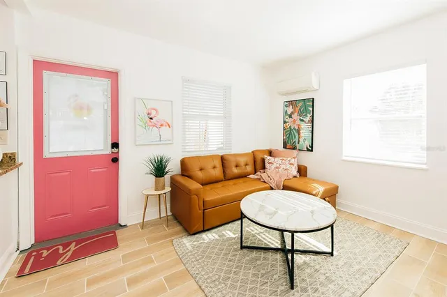 a living room with furniture a flat screen tv and a window