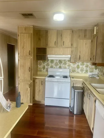 a kitchen with stainless steel appliances granite countertop a sink stove and cabinets