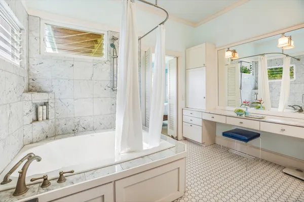 a bathroom with a tub sink and mirror
