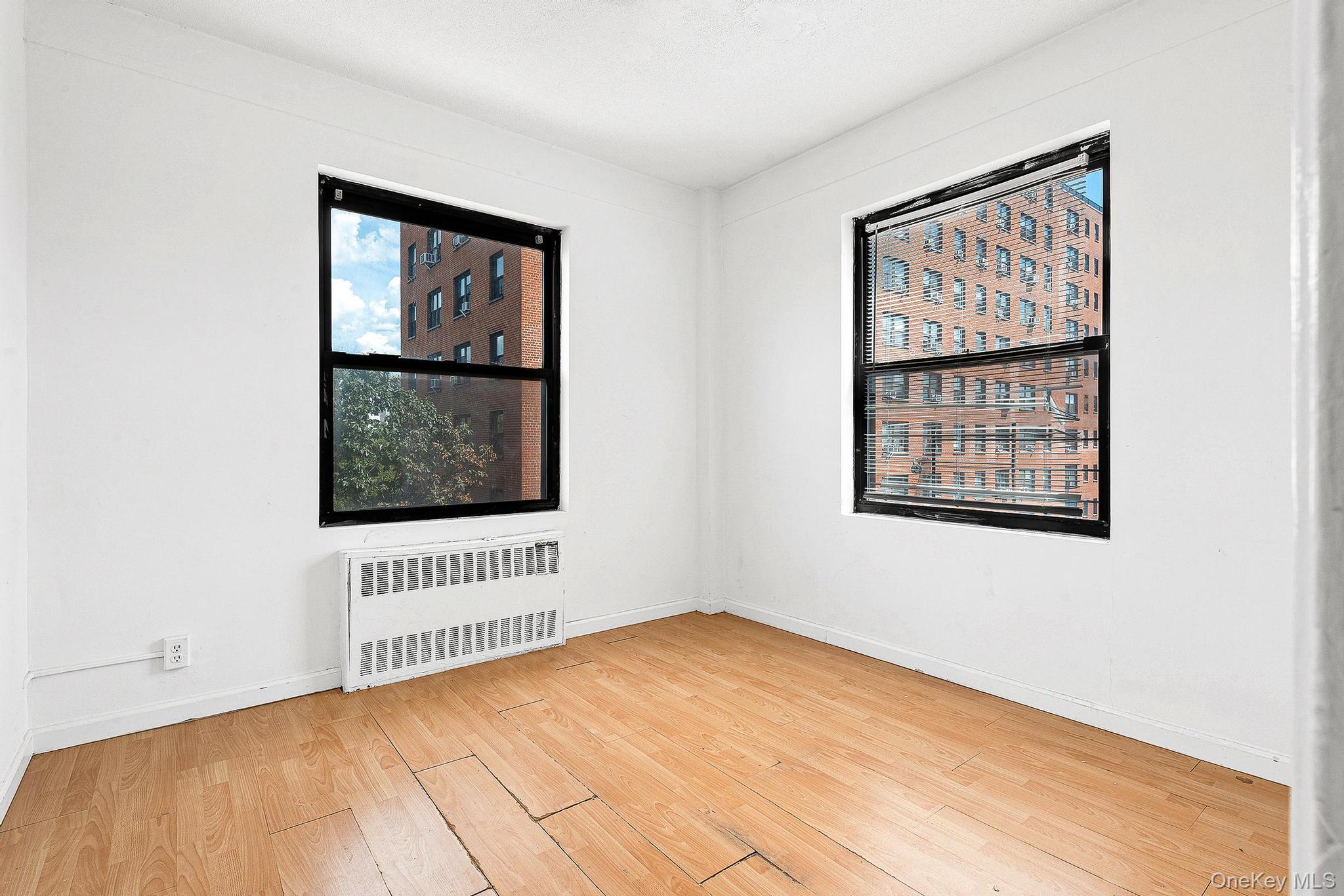 99-32 66th Road, Unit 5B Queens, NY 11374 - Photo 4 of 27 Unfurnished room featuring radiator and light wood finished floors