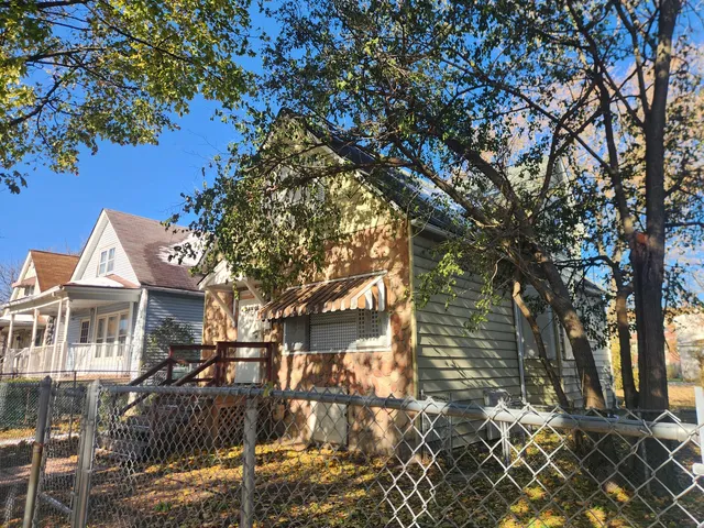 a front view of a house with a tree