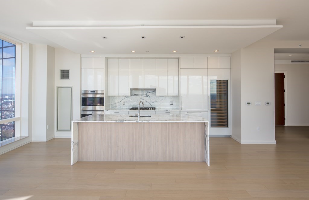 1 Franklin Street, Unit 3903 Boston, MA 02110 - Photo 4 of 26 a large kitchen with kitchen island a sink stainless steel appliances and cabinets