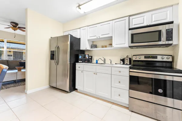 a kitchen with stainless steel appliances a stove a microwave and white cabinets