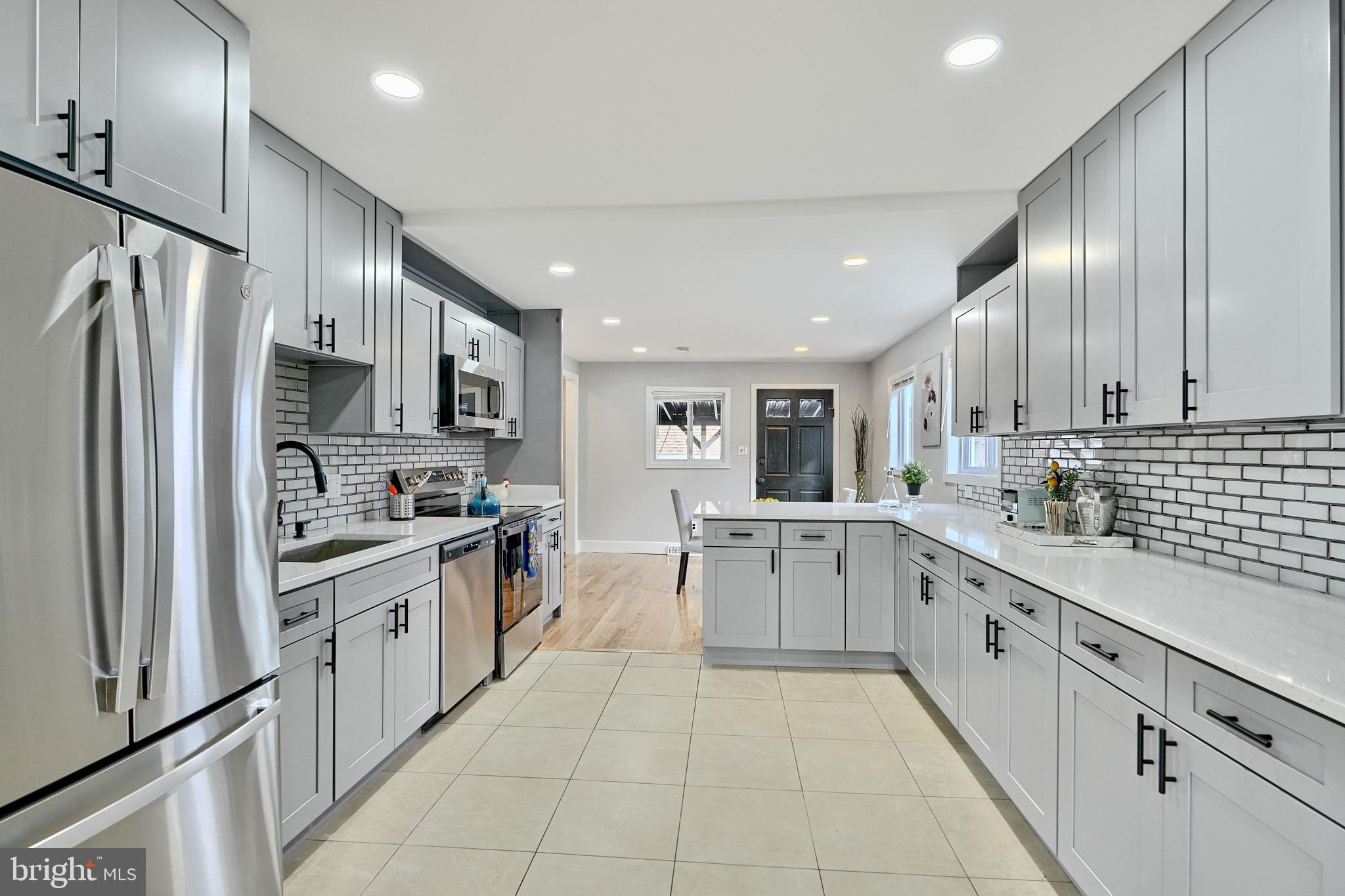 709 Fuselage Avenue Baltimore, MD 21221 - Photo 12 of 36 a large kitchen with stainless steel appliances lots of white cabinets