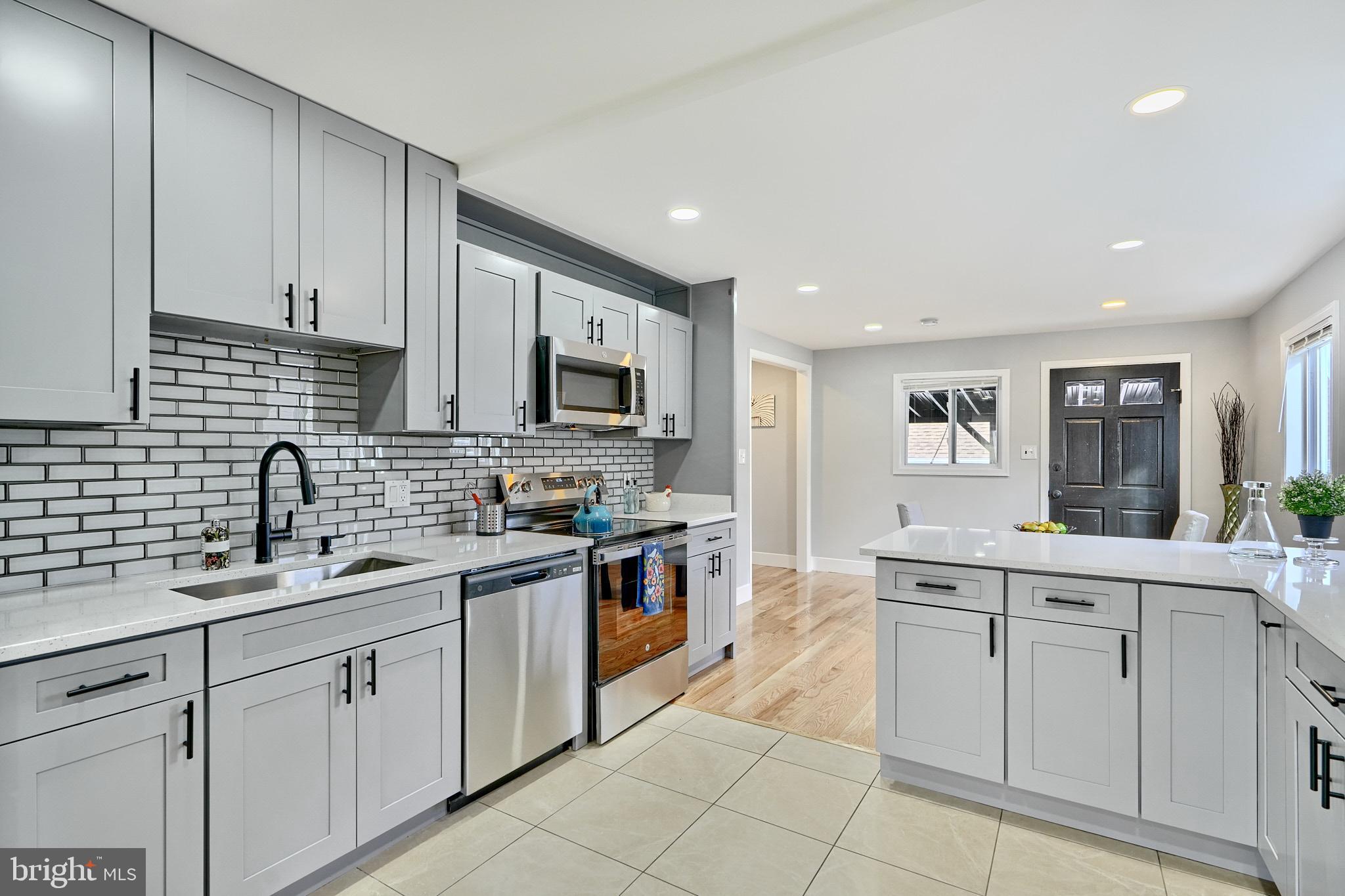 709 Fuselage Avenue Baltimore, MD 21221 - Photo 13 of 36 a kitchen with a sink stove and cabinets