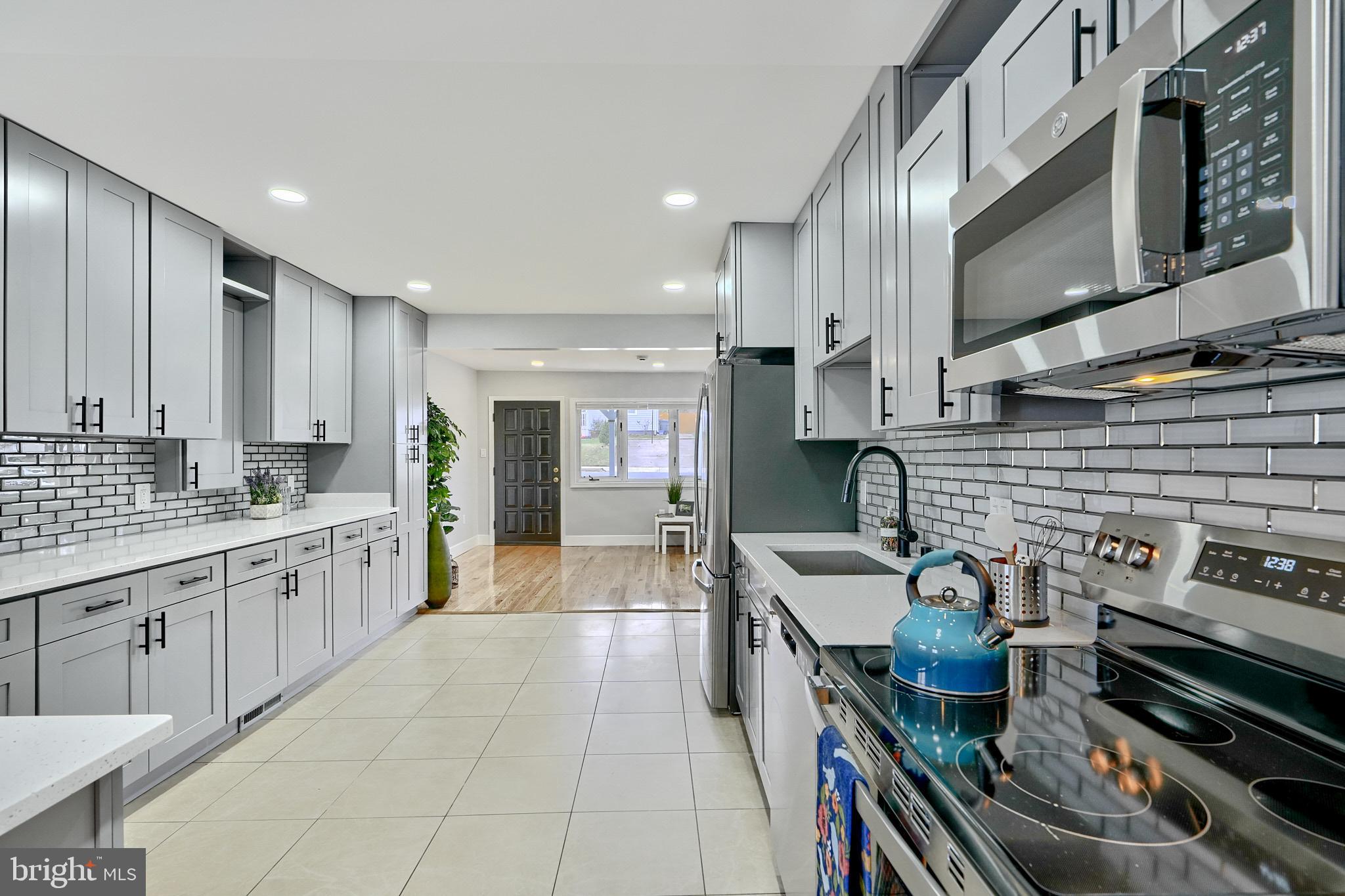 709 Fuselage Avenue Baltimore, MD 21221 - Photo 36 of 36 a large kitchen with stainless steel appliances granite countertop a stove and a sink