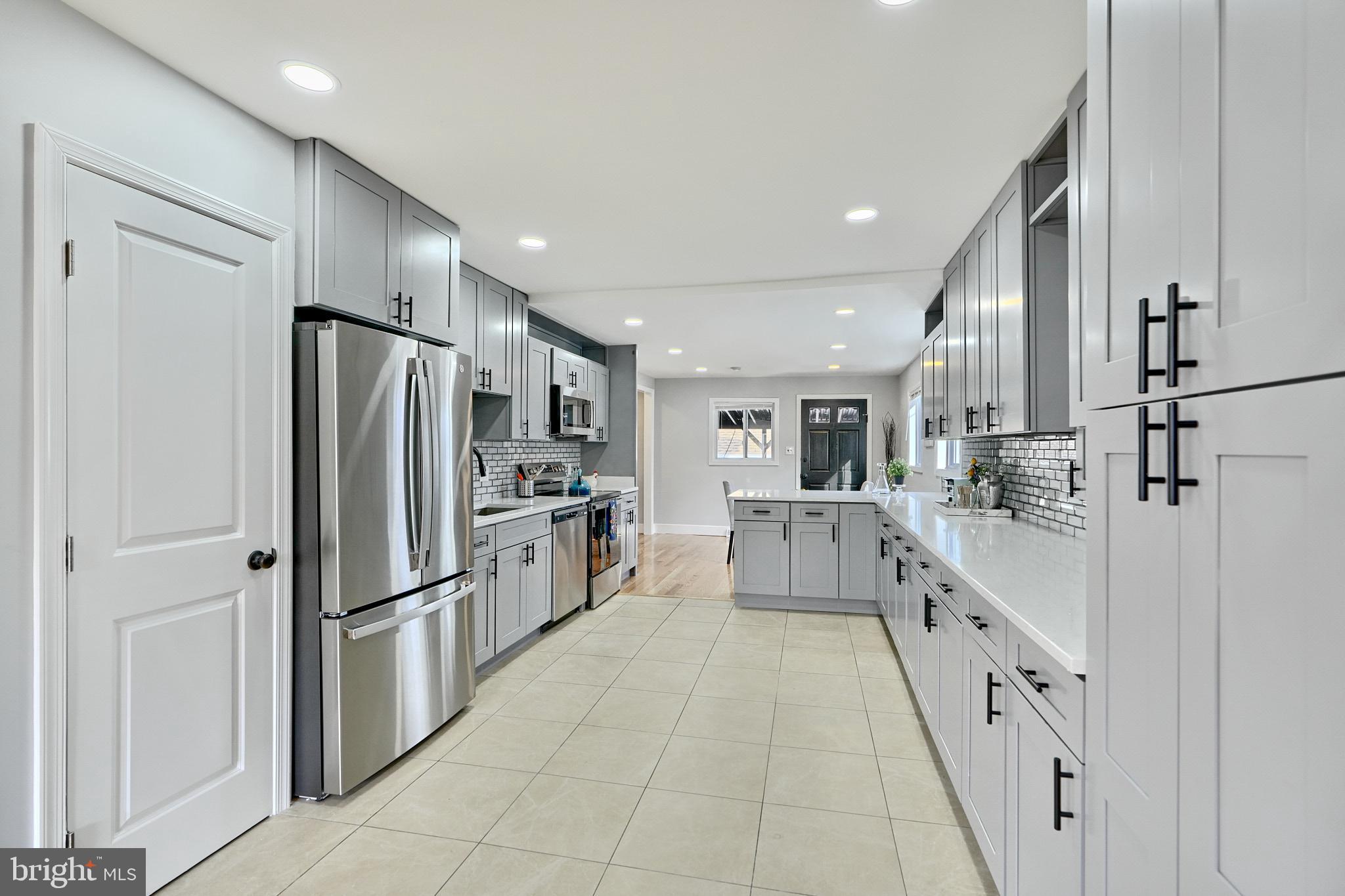 709 Fuselage Avenue Baltimore, MD 21221 - Photo 10 of 36 a kitchen with white cabinets and refrigerator