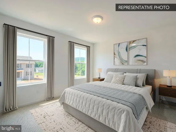 a bedroom with a large bed and a lamp