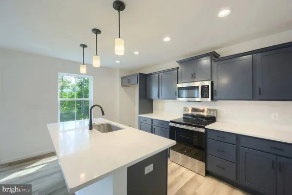 a kitchen with kitchen island a counter space a sink and appliances