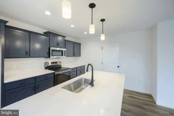 a kitchen with granite countertop a sink a counter space appliances and cabinets