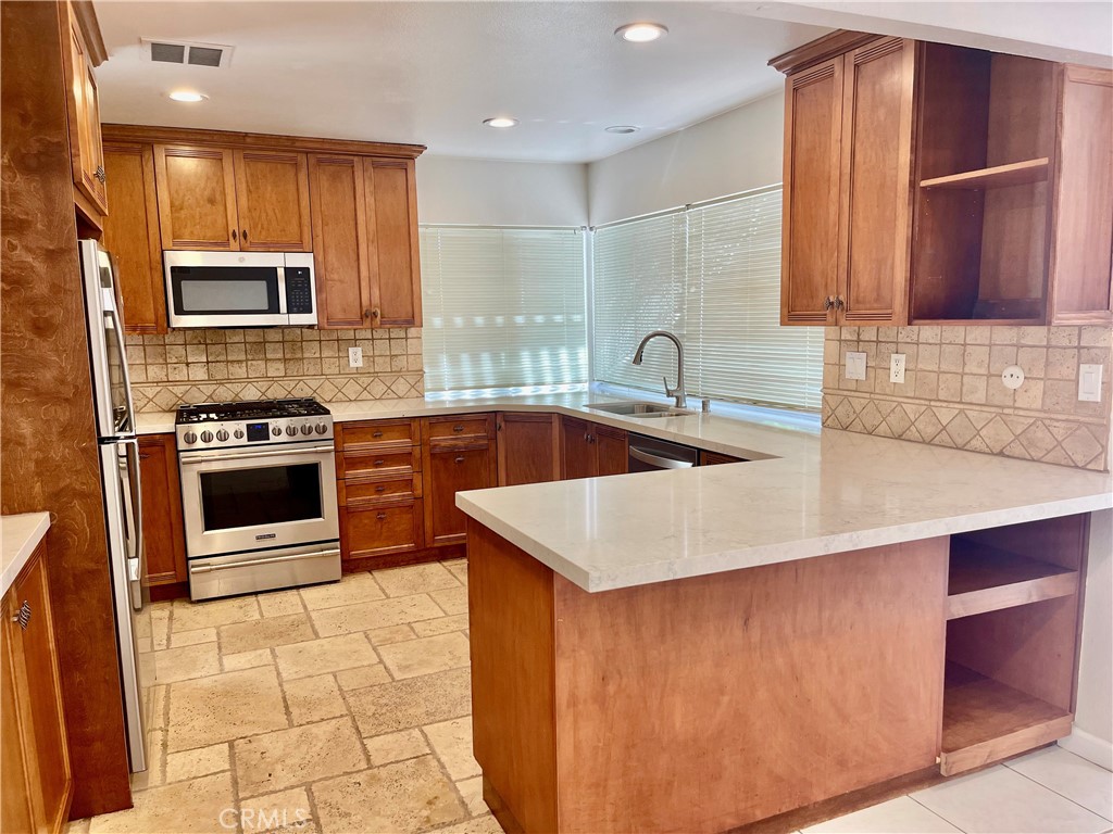 3921 Declaration Avenue Calabasas, CA 91302 - Photo 5 of 26 a kitchen with stainless steel appliances a stove a sink a microwave a refrigerator and cabinets
