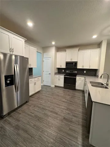 a large kitchen with stainless steel appliances and a refrigerator