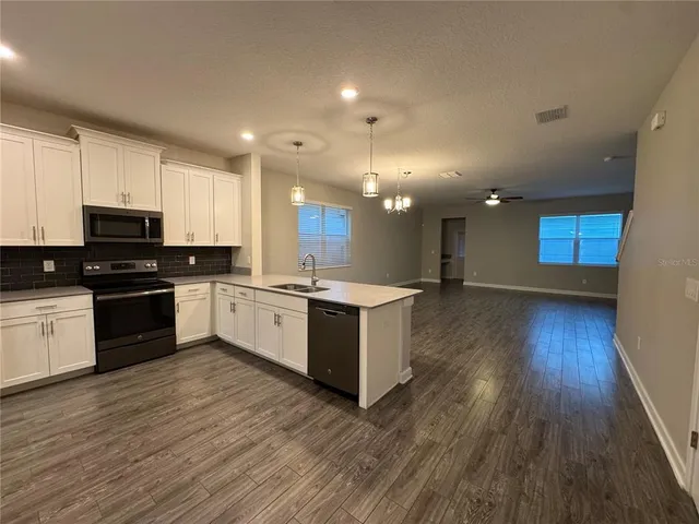 a large kitchen with stainless steel appliances sink and cabinets
