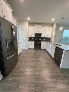 a kitchen with stainless steel appliances granite countertop a refrigerator sink and stove