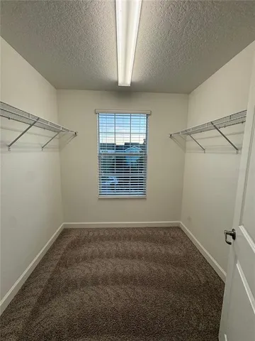 an empty room with wooden floor and a ceiling fan