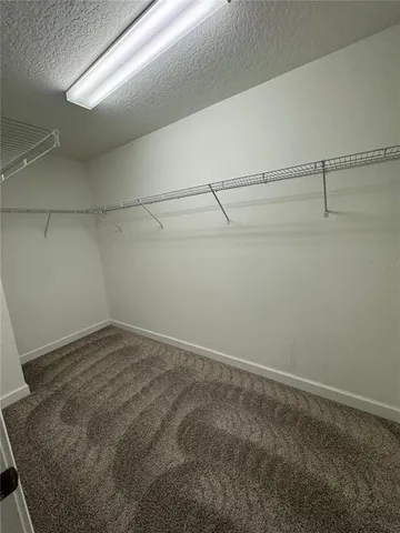 a view of a big room with windows and chandelier fan