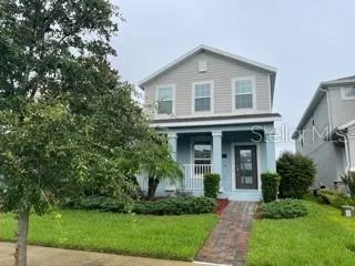 a front view of a house with a yard and potted plants