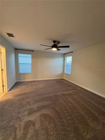 a spacious bathroom with a double vanity sink a toilet and a mirror