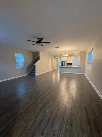 a view of a livingroom with wooden floor and a ceiling fan