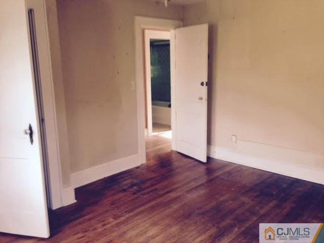 1563 Englishtown Road Old Bridge, NJ 08857 - Photo 1 of 15 an empty room with wooden floor and entrance