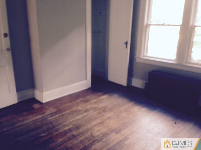 1563 Englishtown Road Old Bridge, NJ 08857 - Photo 3 of 15 an empty room with wooden floor and windows